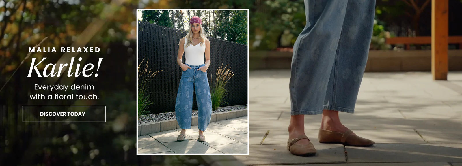 Woman wearing blue jeans with floral details, standing outdoors on a stone path.